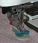 Hovedbilde (5F18) Janome Knapp-i-syings fot - T Gr.1